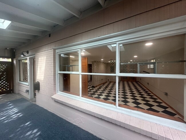 Porche delantero cubierto con vista a la sala de estar. - 5590 W 1st Ave