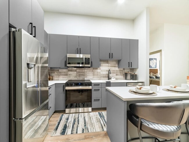 Gourmet kitchens showcase quartz countertops, custom cabinetry, stainless steel appliances, and a stylish tile backsplash.