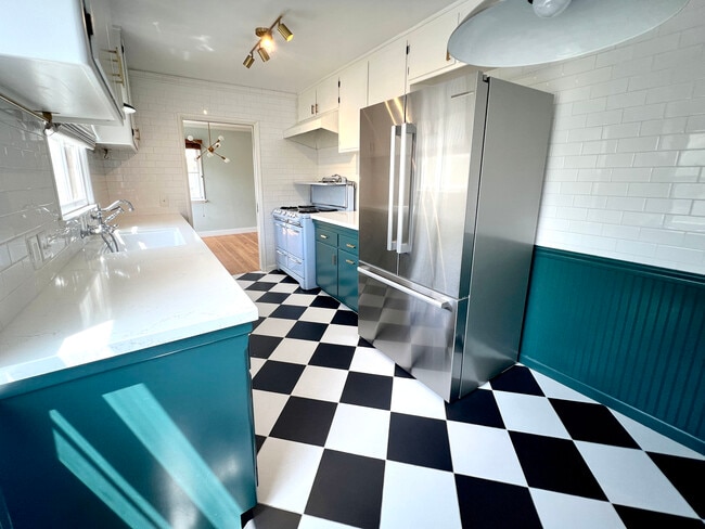 Kitchen with stainless steel refrigerator, refurbished vintage O'keefe and Merritt stove. - 1327 N Central Ave Unidad #F