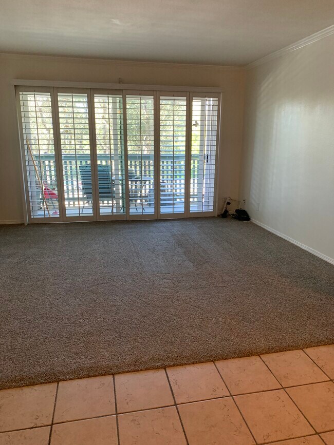 Living room with plantation shutters and new white vinyl double paned sliding glass doors - 436 N Bellflower Blvd Unidad 218 Rental