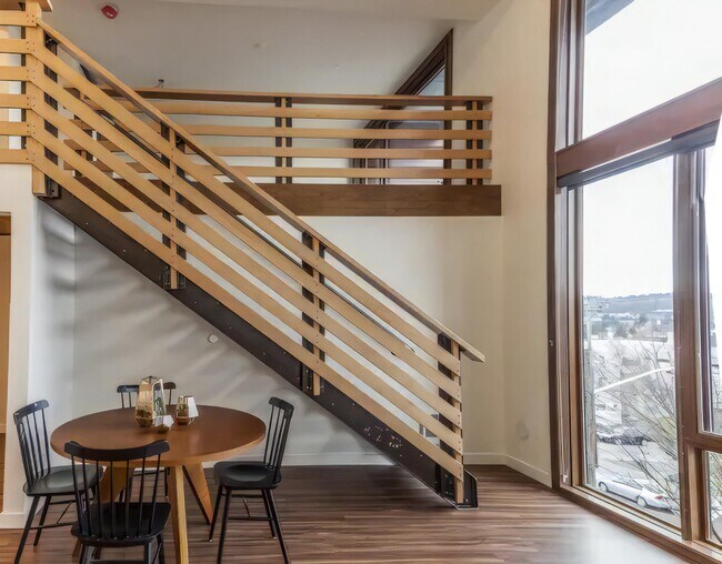 Running the stair up one wall leaves the floor clear for a full dining set.