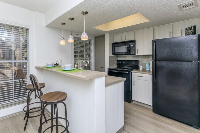 WELL-LIT BREAKFAST BAR WITH LARGE KITCHEN PANTRY - Villages at Timberglen Apartments