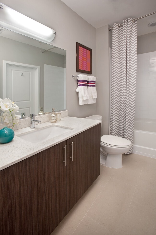 Bathroom with white quartz countertop, espresso cabinetry and hard surface flooring