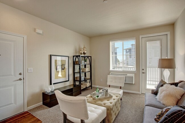 A cozy living room with a large window looking out to the property and access to the private patio - Solara