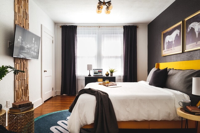 A sophisticated bedroom with bold contrasts, featuring sleek black and gold decor, soft lighting