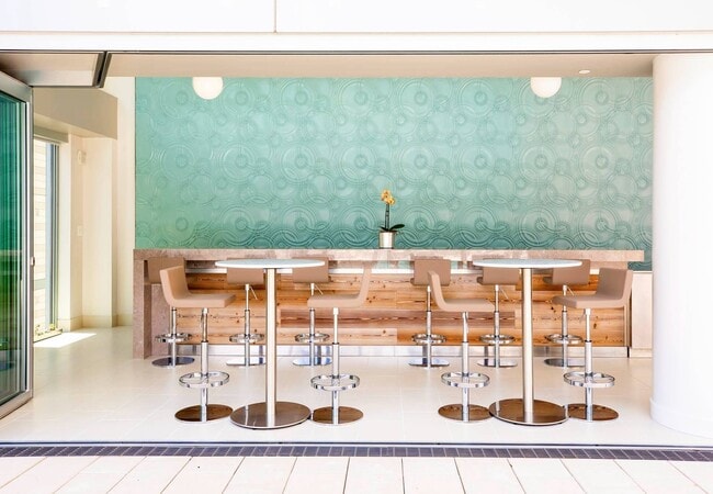 Disfrute de una bebida o una comida informal en el elegante bar junto a la piscina.