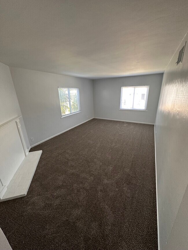 Spacious living room, recently updated with fresh paint and new carpet - 6333 MacArthur Blvd Apartments Unit 6333 MacArthur Blvd