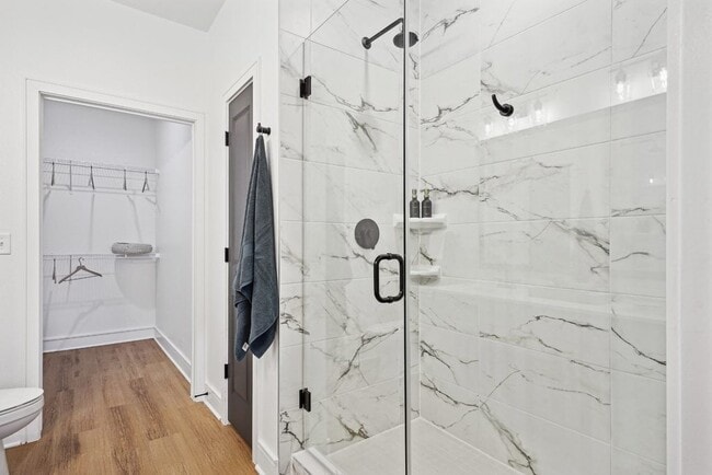 Baño con encimeras de cuarzo, lavabos dobles, ducha a ras de suelo y vestidor