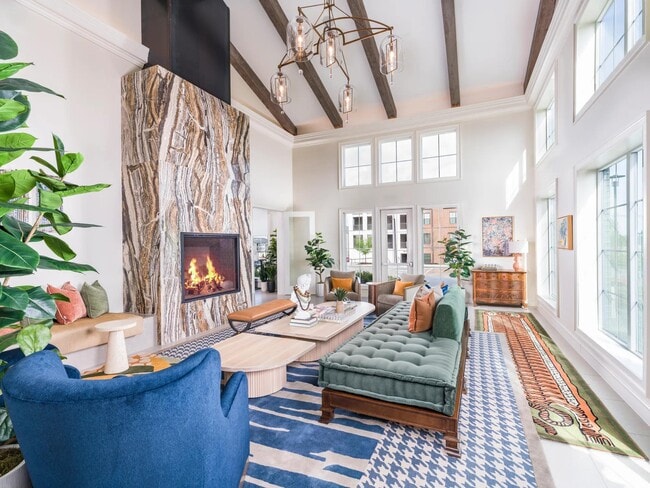 Sofisticado salón club con abundante luz natural, acabados de diseño y una cálida y acogedora chimenea. - Modera McKinney Ridge