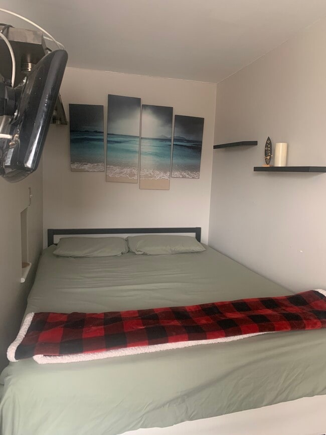 Cama de matrimonio, separada del salón por una pared divisoria. - 2939 Van Ness St NW Unidad 1229
