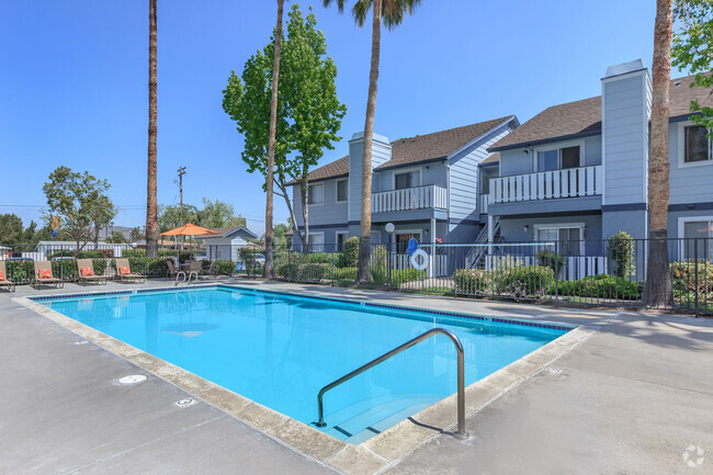 Image of the community swimming pool and welcoming lounge chairs in the background. - Camden Park Rental