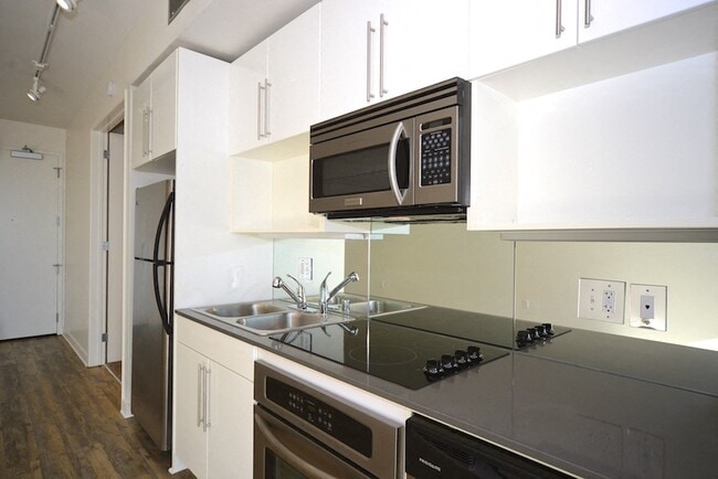 Kitchen with easy clean range top white cabinets at 12th Street Lofts in National City, California.