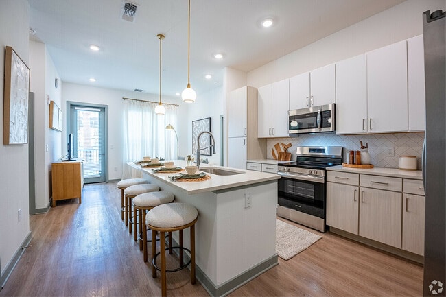 Modern apartment kitchen with sleek white cabinetry. - Livano Sunlake