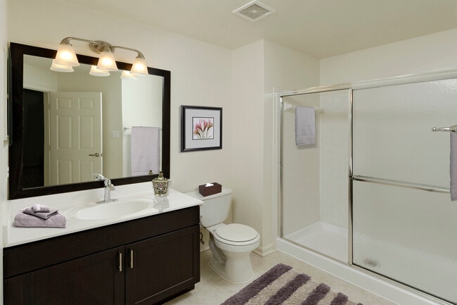 Renovated Package III bath with espresso cabinetry, white countertops, and vinyl tile flooring