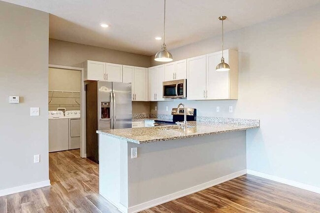 Cook, dine, and gather with ease in this modern kitchen featuring granite countertops, stainless steel appliances, and a spacious breakfast bar.