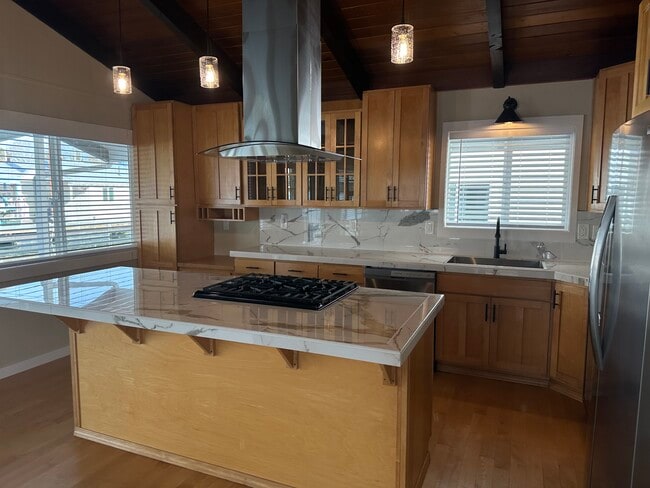 The quality kitchen features a large island for entertaining. - 1879 N Jantzen Ave