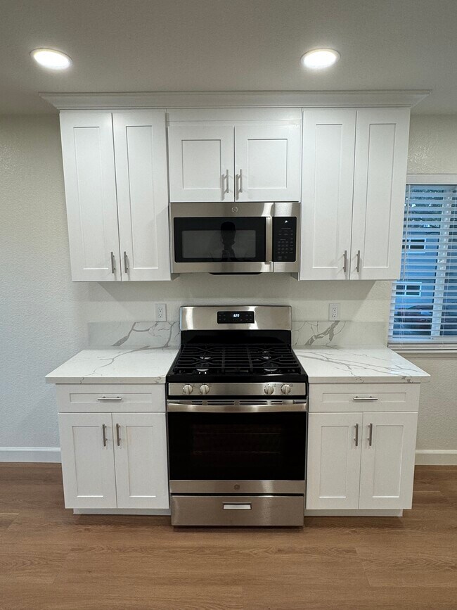 Kitchen gas stove & microwave - 4903 Cowell Blvd Unit Oasis Apartments A C D