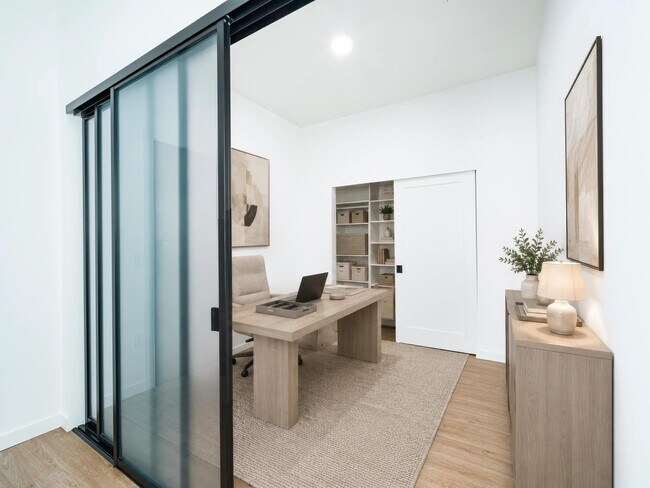 Flexible home office with a sliding glass partition, built-in shelving, and a clean layout that supports focus and everyday productivity.