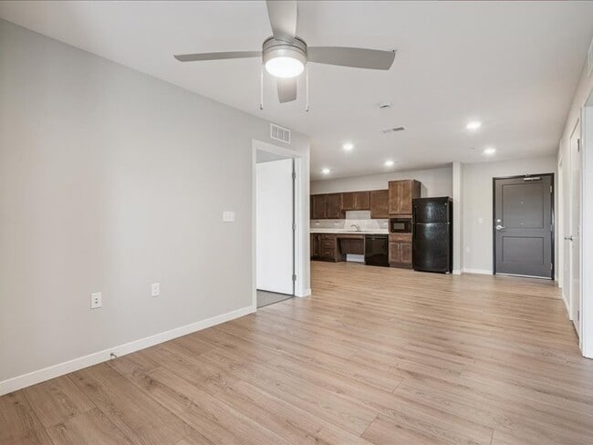 Sala de estar con suelo de vinilo de lujo y ventilador de techo - NEX Senior - ARRO Senior (55+) Apartments