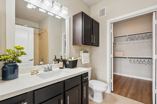 Bath with dark cabinetry, white quartz countertops, and hard surface flooring