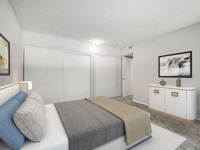 Large carpeted private bedroom showing sliding door closets.