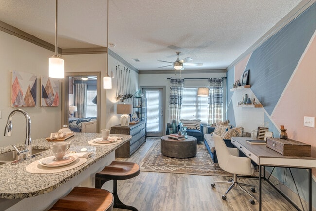 Kitchen with pendant lighting and living area with hard-surface flooring