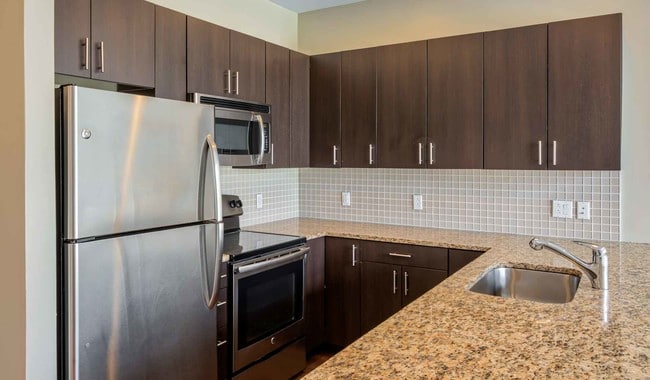 Cocinas modernas con electrodomésticos de acero inoxidable y encimeras de granito