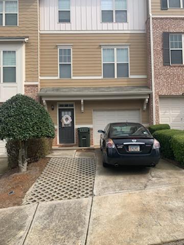 Front door and garage entrance with additional parking space - 1798 Oakbrook Ln NW Townhome