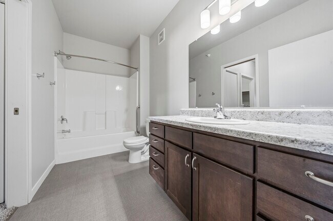 Elevate your lifestyle at North Highlands Apartments with this spacious and modern bathroom featuring elegant countertops and ample storage. Perfectly designed for comfort and convenience. Schedule a tour today to see it in person! - North Highlands Apartments and Villas