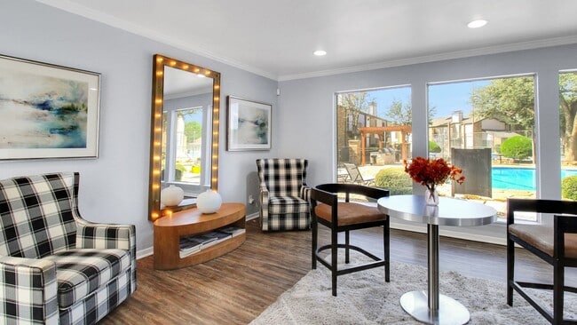 Chic lounge area with modern decor, large windows overlooking a stunning pool and landscaped courtyard, perfect for relaxation and socializing. - Advenir at The Meadows