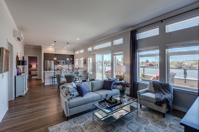 Our open living room and kitchen space includes a counter-level breakfast bar, large windows with ample natural light, and beautiful hard-wood style flooring.