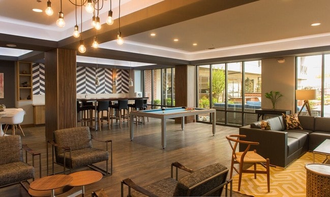 Relájate después de un largo día de trabajo en tu salón estilo centro turístico. - The Residences at Harlan Flats