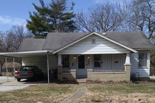 Classic craftsman with large covered porch, custom flower planters, and covered parking.