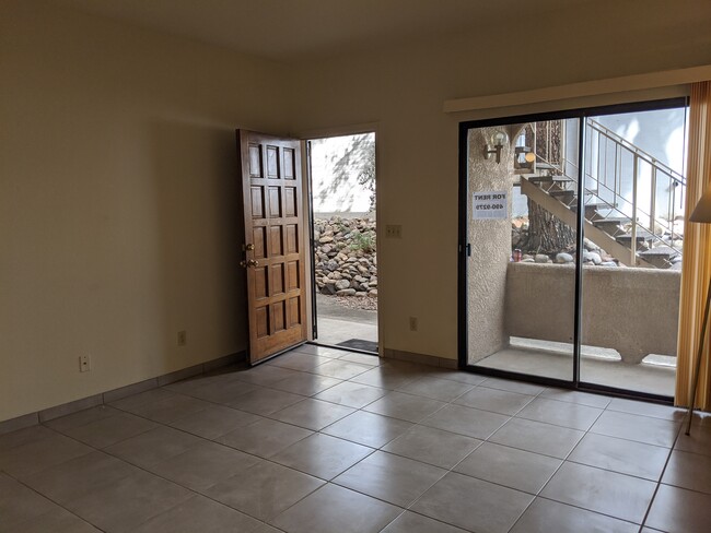 Living room with sliding door out to small patio. - 5750 N Camino Esplendora Apartment Unit 120