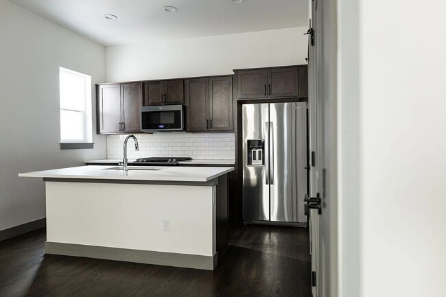 Cocina completa con electrodomésticos de acero inoxidable, que incluyen microondas, cocina a gas, lavavajillas y refrigerador. - 3505 S Marion St