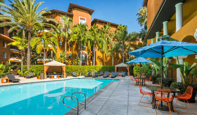 Piscina estilo centro turístico con reposeras y mesas cubiertas - Palazzo East Apartments