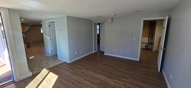 Living room, bathroom door on left, Bedroom 1 in the middle, Laundry on right - 103 S Main St Unit Basement