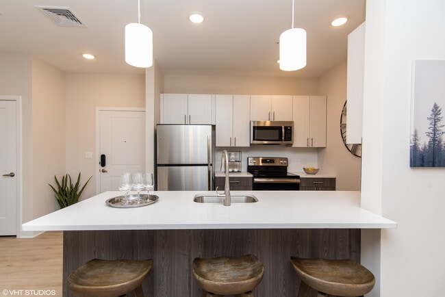 Gorgeous kitchen space with quartz white countertops and stainless steel appliances - The Preserve at Great Pond Apartments