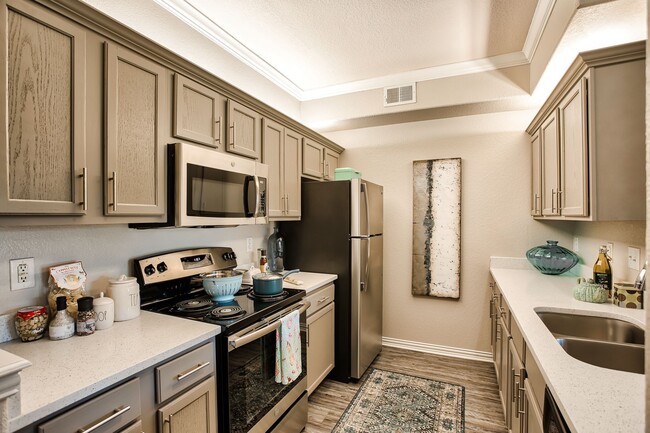 Kitchen featuring all stainless front appliances, large quartz counter tops, and grey cabinets. - Ellery at  Lake Sherwood Apartments