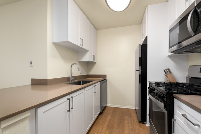 Renovated I kitchen with quartz countertops, stainless steel appliances, and hard surface flooring