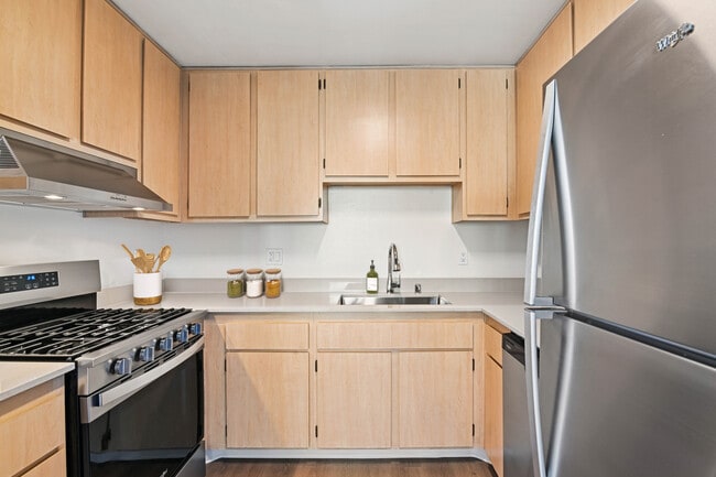 Classic Package II kitchen with stainless steel appliances, oak cabinetry, beige quartz countertops, and hard surface flooring - eaves Mission Ridge