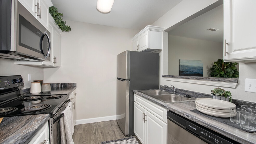 Cook with ease in kitchens featuring stainless steel refrigerators and black stove top ovens, professionally operated by Highlands Vista Group.