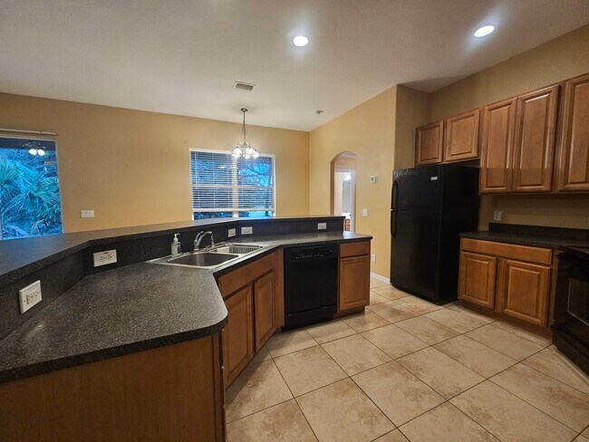 Large modern kitchen next to laundry room and entrance to 3 car garage - 3615 Soft Breeze Cir