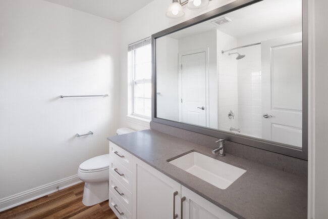 Bath with white cabinetry, grey quartz countertop, and hard surface flooring
