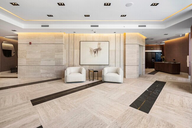 Grand lobby with travertine flooring, walnut paneling, and designer lighting