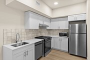 Bright, modern kitchen featuring stainless steel appliances, white cabinetry, and a stylish tile backsplash.