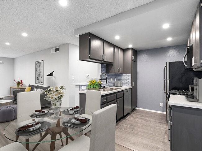 Los pisos de madera noble en comedor con vista del área de la cocina con azulejos. - Woodridge Apartments