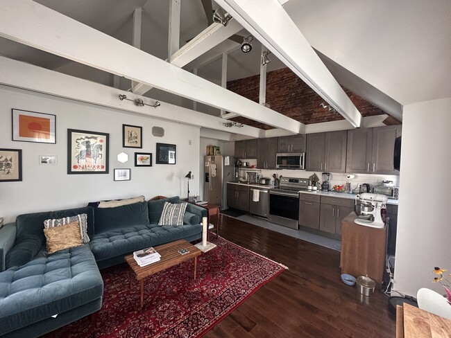 Living & Kitchen area with loft ceiling and exposed brick - 4818-3 Baltimore Ave Apartments Unit 4818 Baltimore 3rd flr