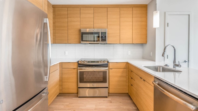 Kitchen with Glass Tile Backsplash and Stainless Steel Appliances