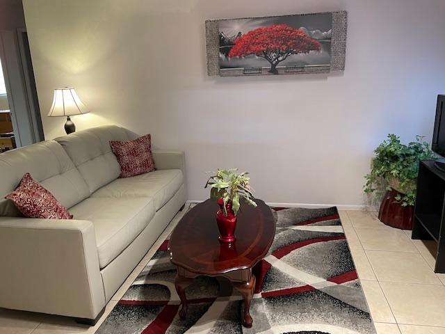 Living area with TV and large leather couch - 5921 E Boston St Unit Casita